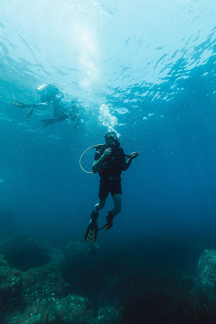 Scuba diver preparing to surface from the sea under bright natural light