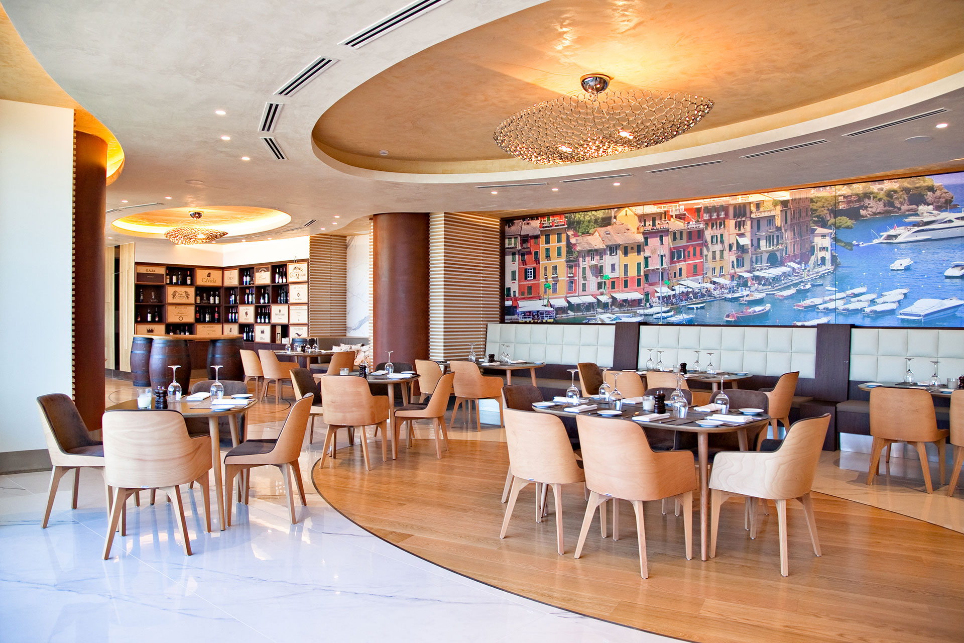 Stylish Portofino restaurant with wooden decor, wine display and Portofino harbor mural