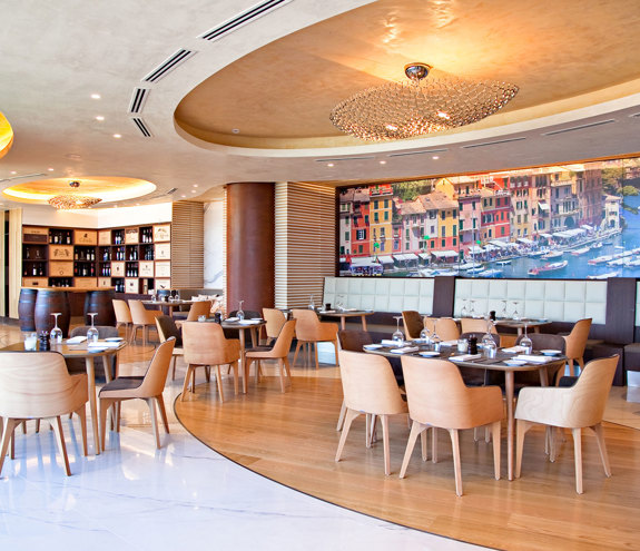 Stylish Portofino restaurant with wooden decor, wine display and Portofino harbor mural