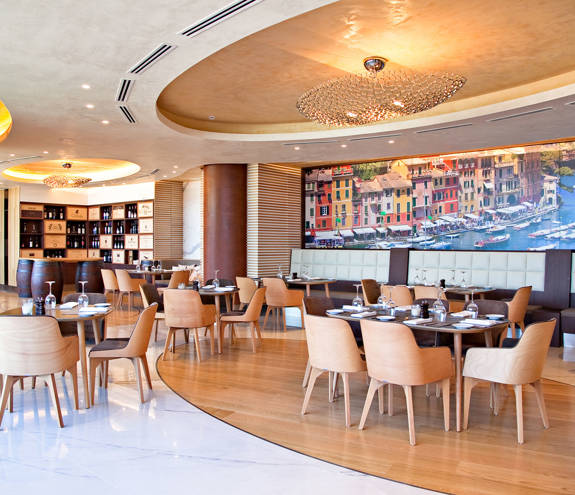 Portofino Restaurant tables with sofas and chairs and a decorated wall