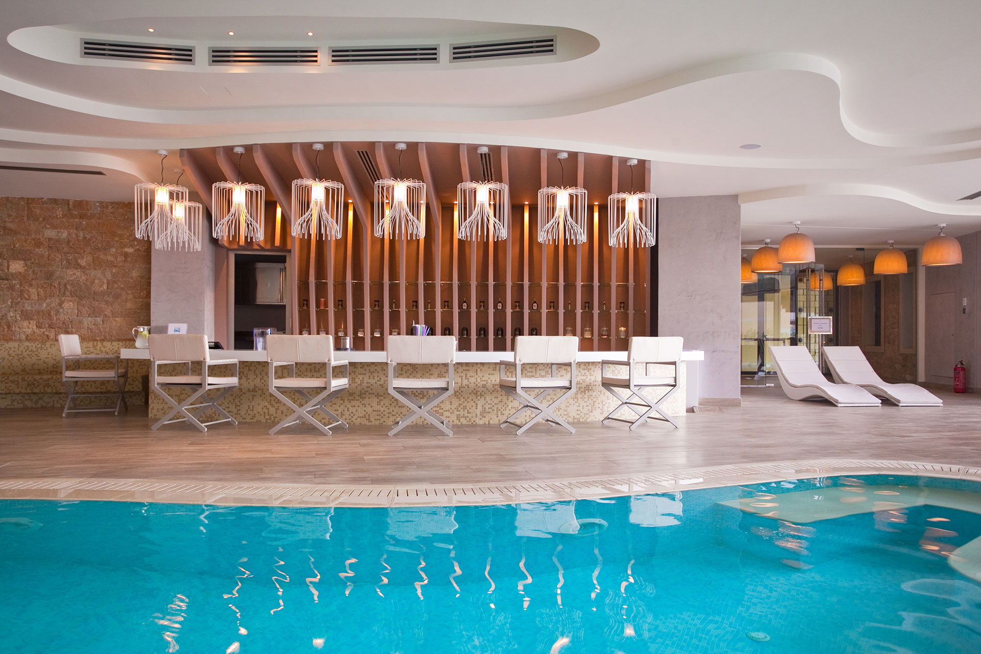 Modern Myrthia Health Bar beside stylish loungers by the indoor pools, creating a calm atmosphere