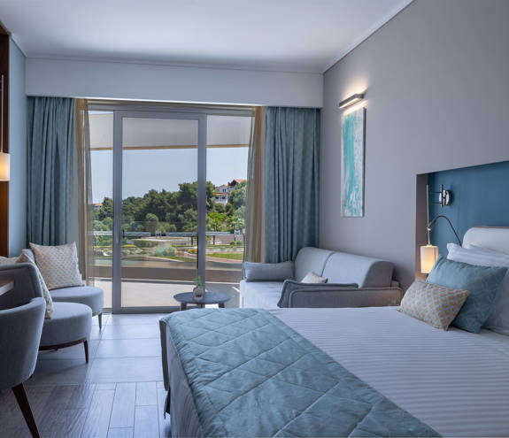 Deluxe Side Sea View bed, sofa, chairs and amenities