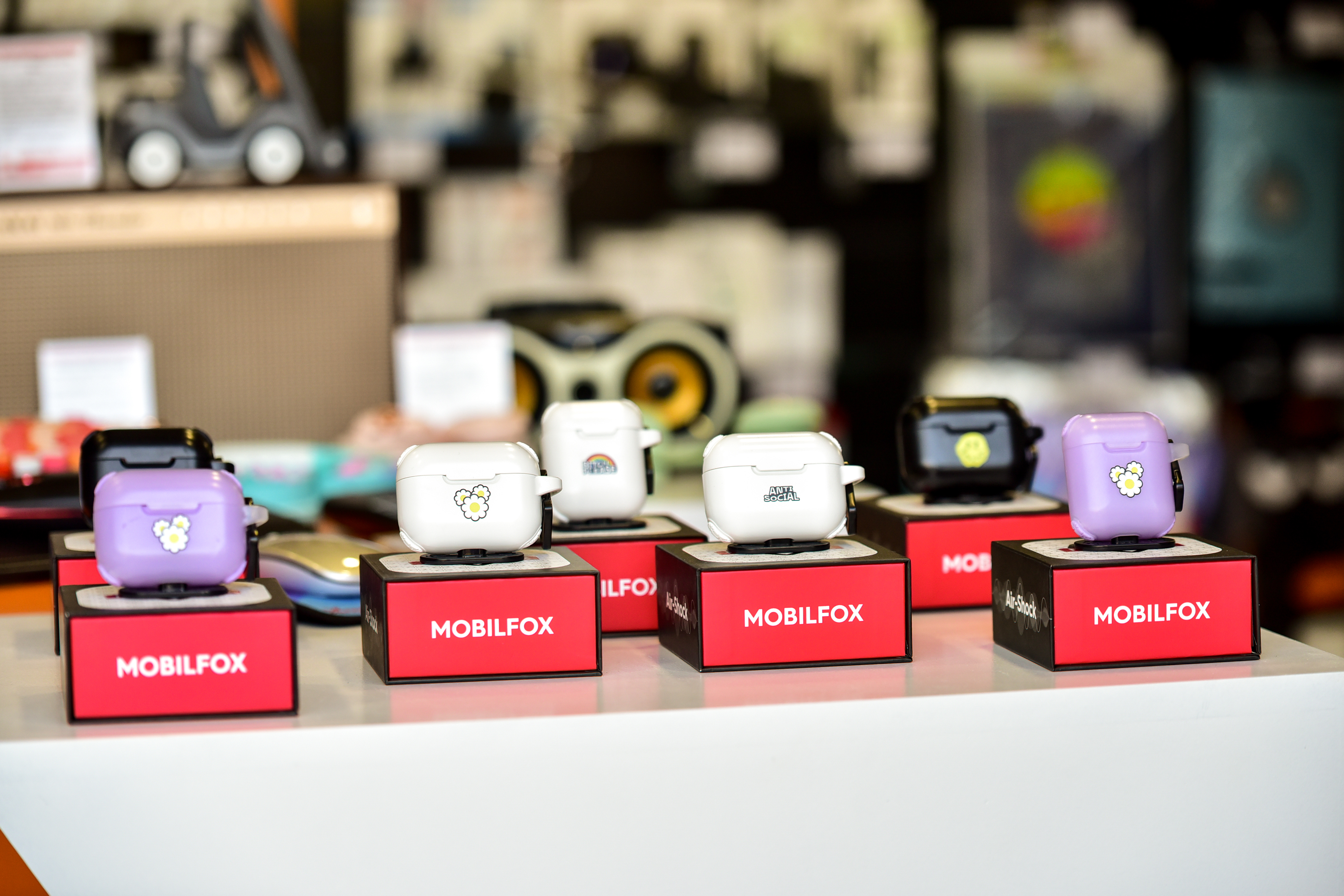 Colorful Mobilfox wireless earphone cases with playful designs displayed on counter