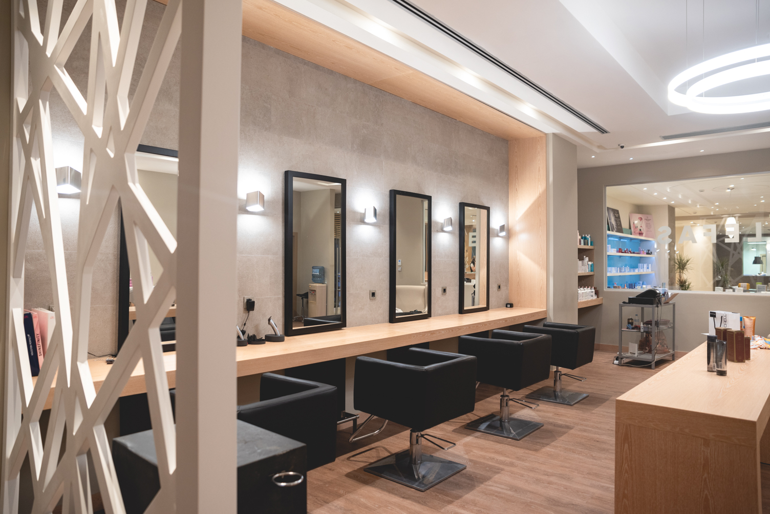 Stylish stations with modern chairs and large mirrors in the hair salon at Miraggio Resort
