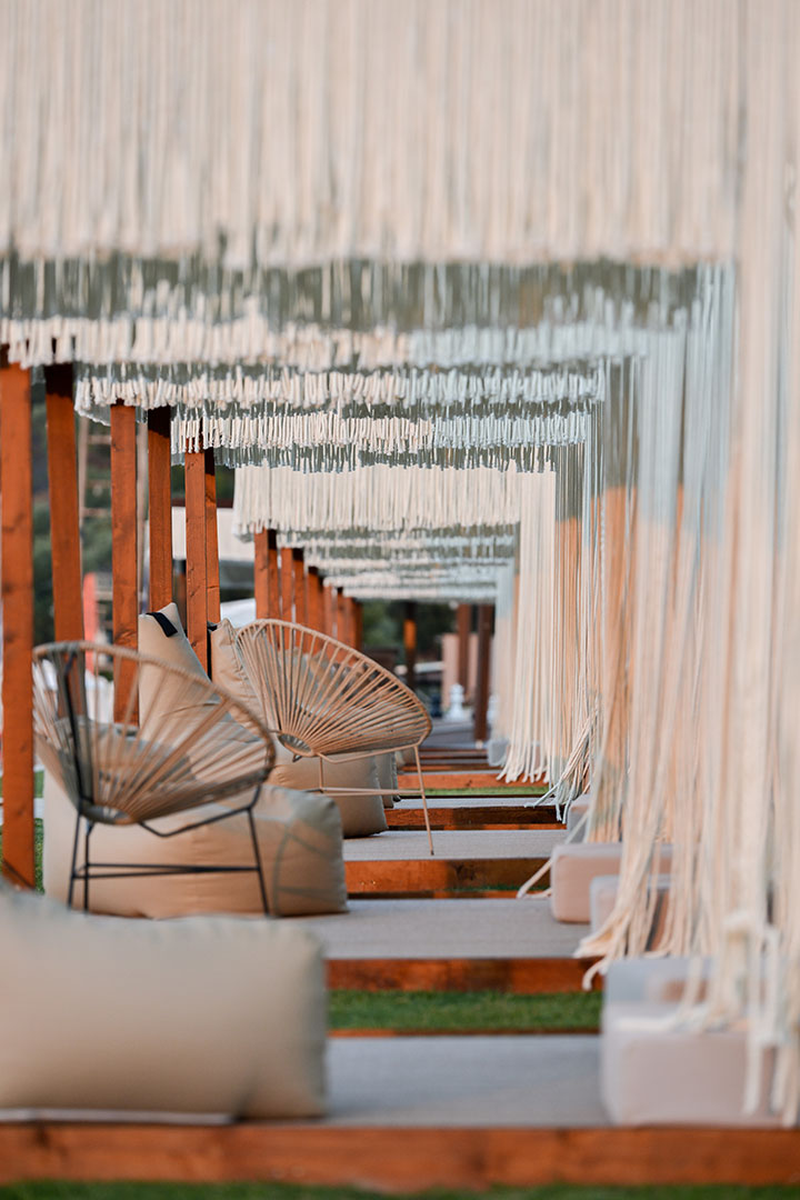 Stylish cabanas with fringe curtains, bean bags, and chairs arranged in a serene row