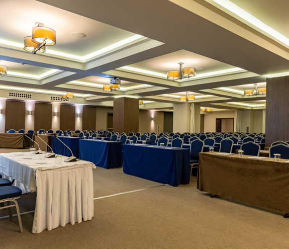 Spacious conference hall with elegant lighting, podium, and neatly arranged seating setup for corporate events