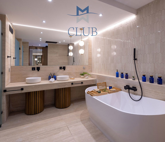 Suite's modern bathroom with frosted glass doors, twin basins, and a freestanding bathtub