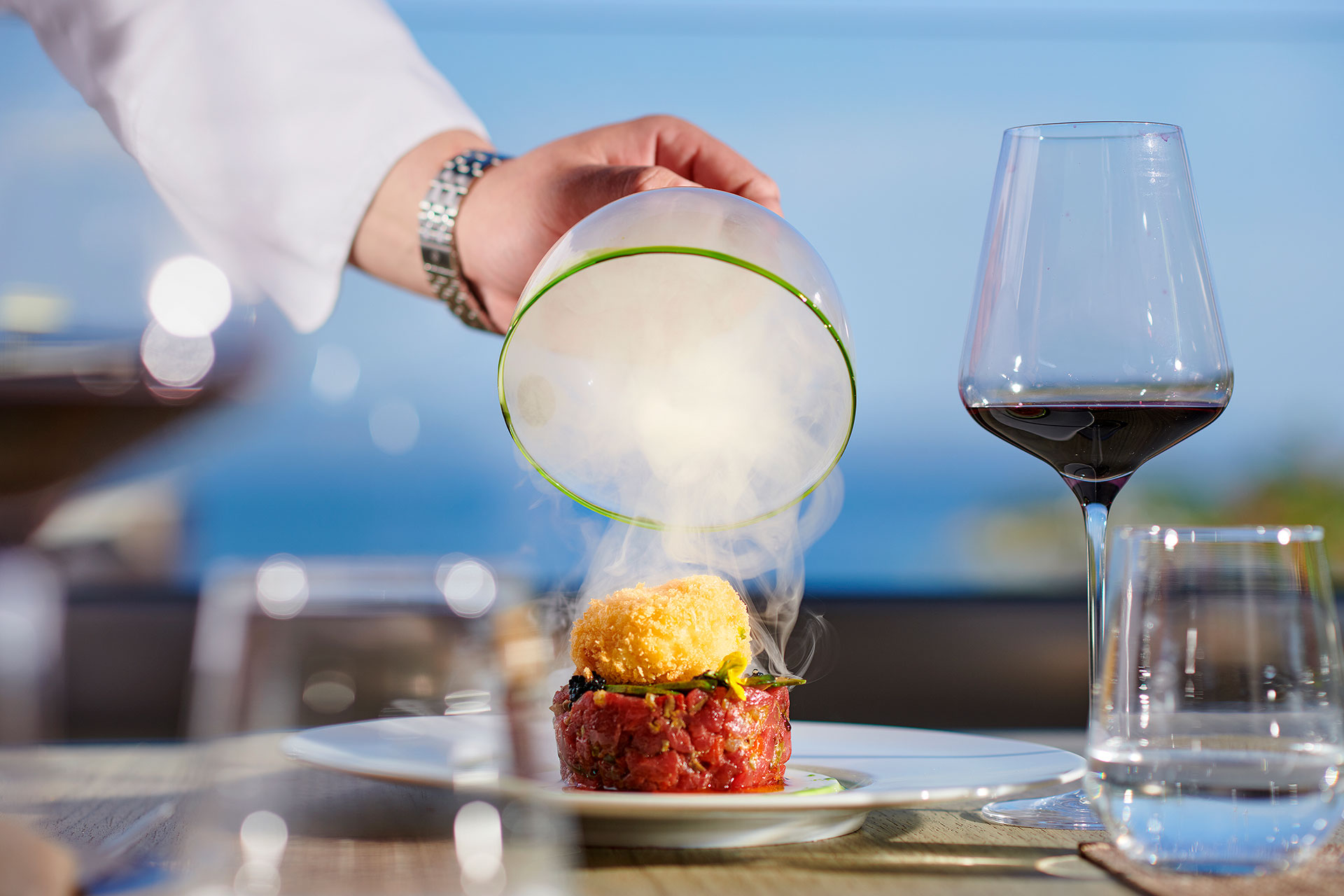 Gourmet dish unveiling with smoke effect at Sommelier's 8 restaurant fine dining terrace