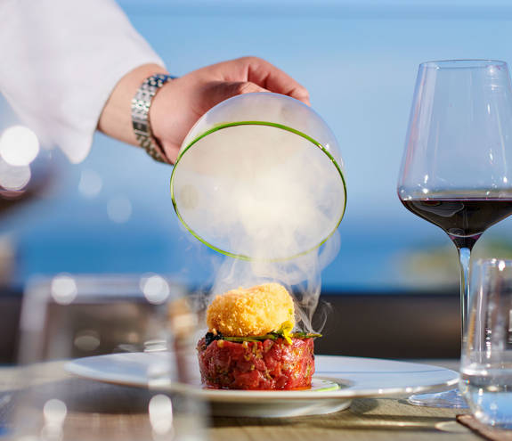 Served dish with lifted up covering lid