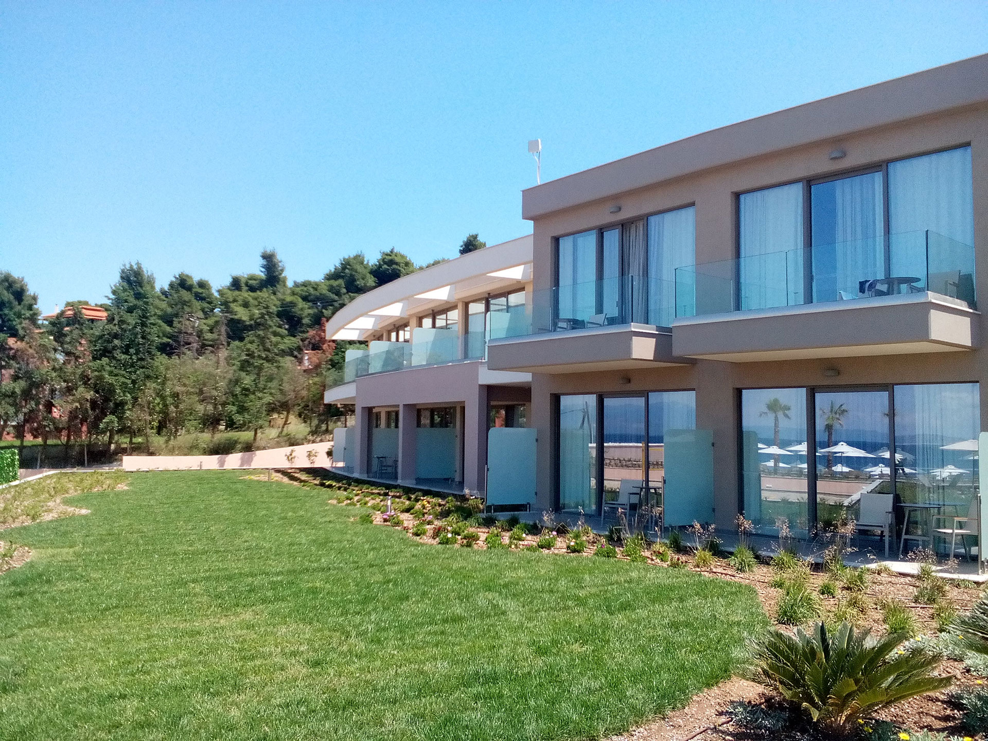 Exterior view of deluxe rooms with private balconies, surrounded by lush greenery
