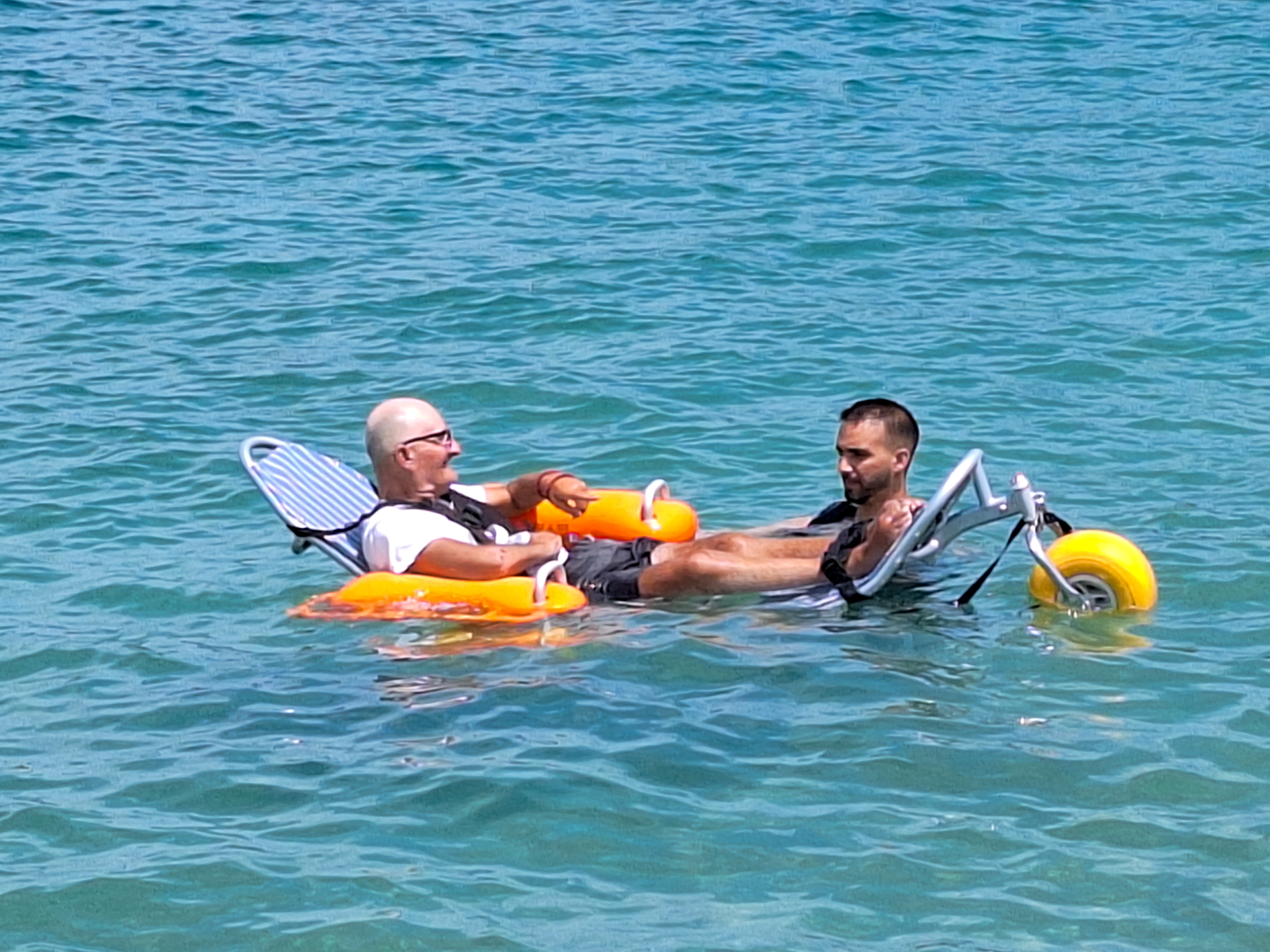 Guest enjoying floating wheelchair assistance in the calm turquoise sea