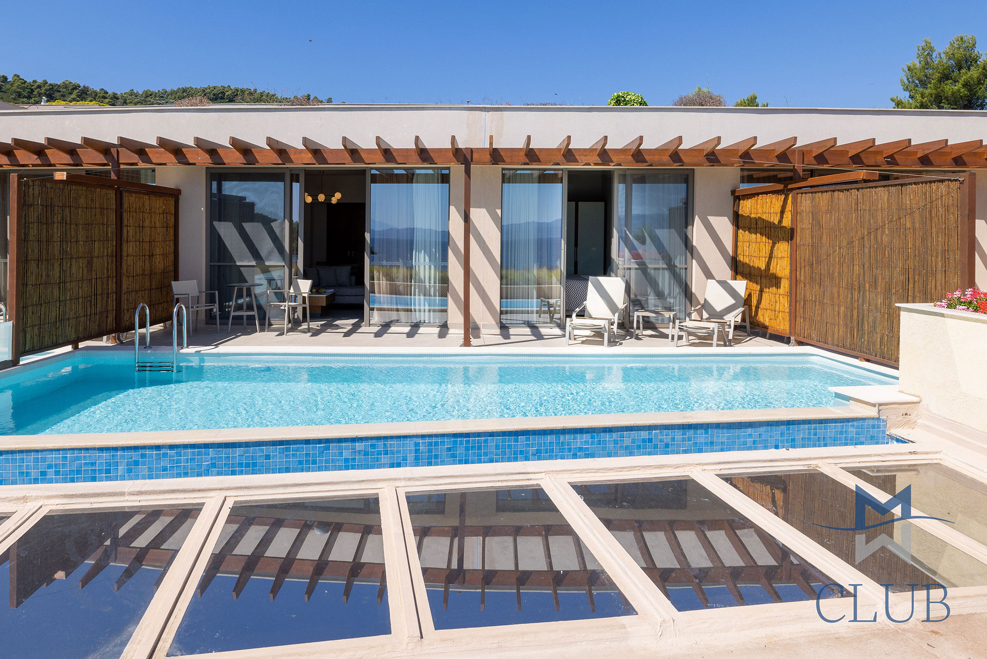 Exterior view of a private terrace of a suite with wooden pergola, sun loungers and private pool