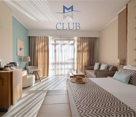 Spacious club sea view room with working desk, king size bed, cozy seating area and light blue accents