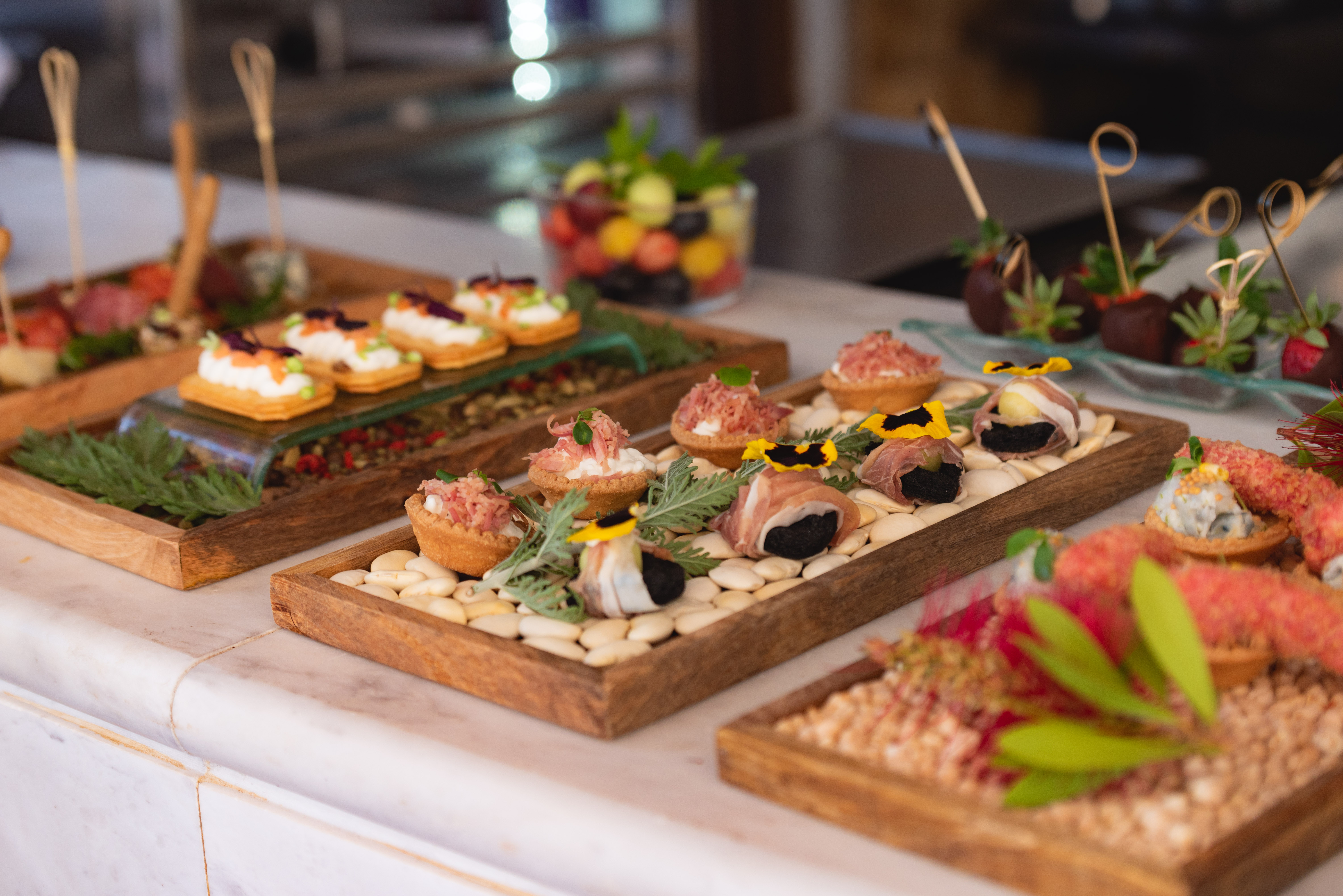 Gourmet wedding appetizers and canapes beautifully arranged on wooden trays