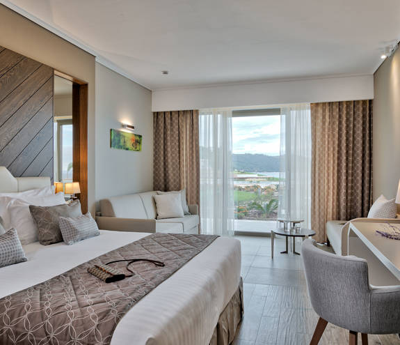 Deluxe Garden View Room bed, sofa, chair and amenities