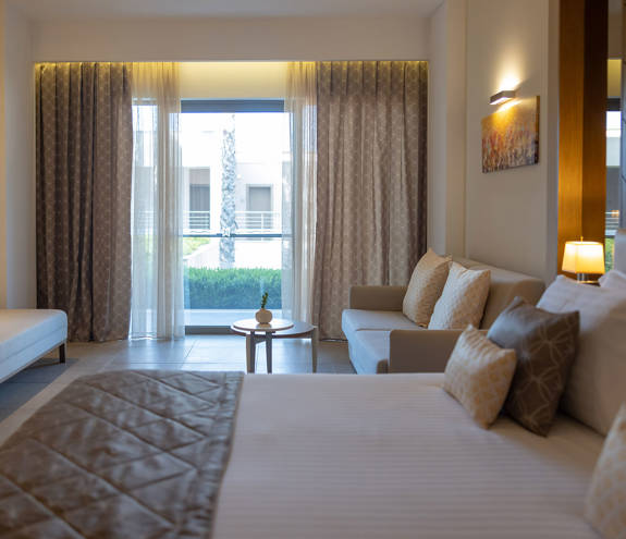 Deluxe Garden View Room bed, sofa and balcony view