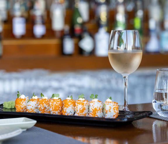 Sushi Bar sushi dish next to a glass of water and a glass of wine