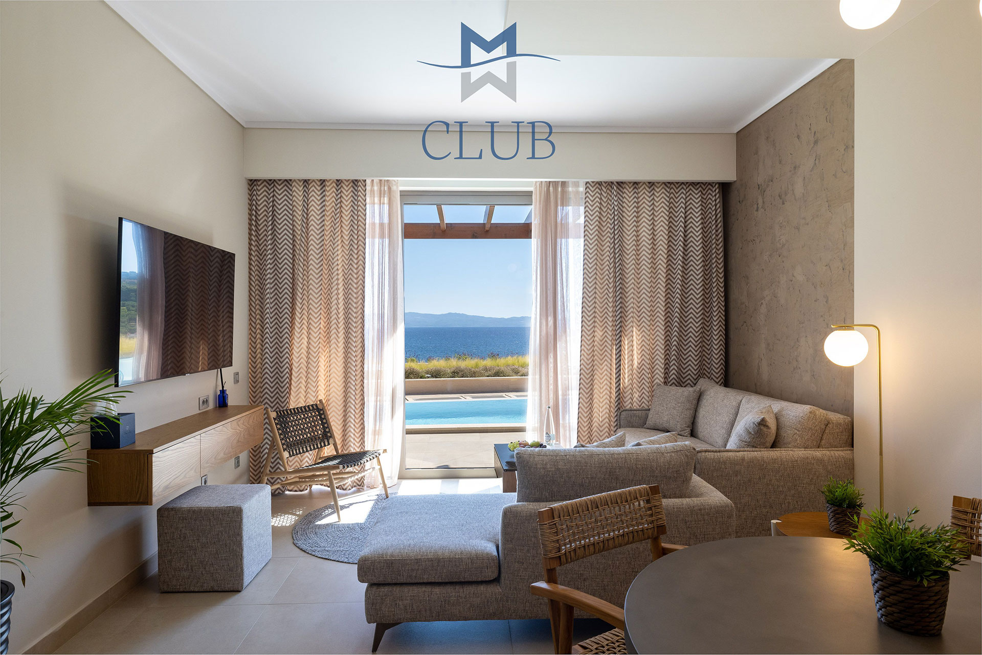 Modern suite living area, with dining table, corner sofa, wall mounted TV and balcony doors with access to private pool