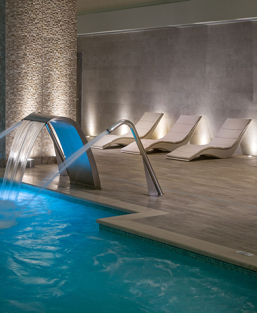 Heated indoor pool with hydrotherapy jets and elegant loungers