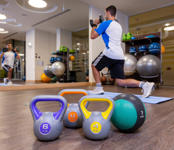 Gym equipment ang weight with a guest working out in the background