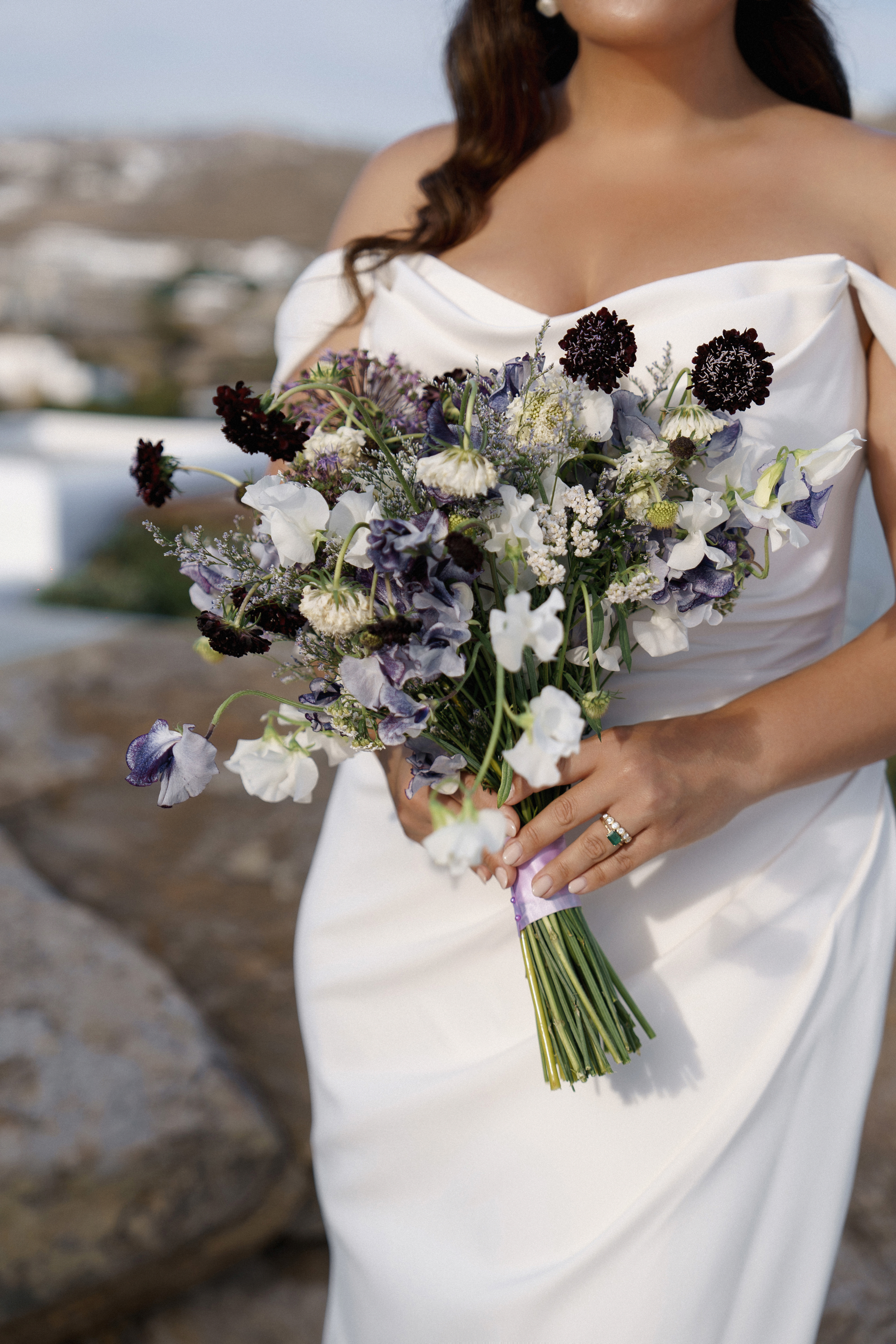 Bride holding bouquet of purple, lilac, and white flowers