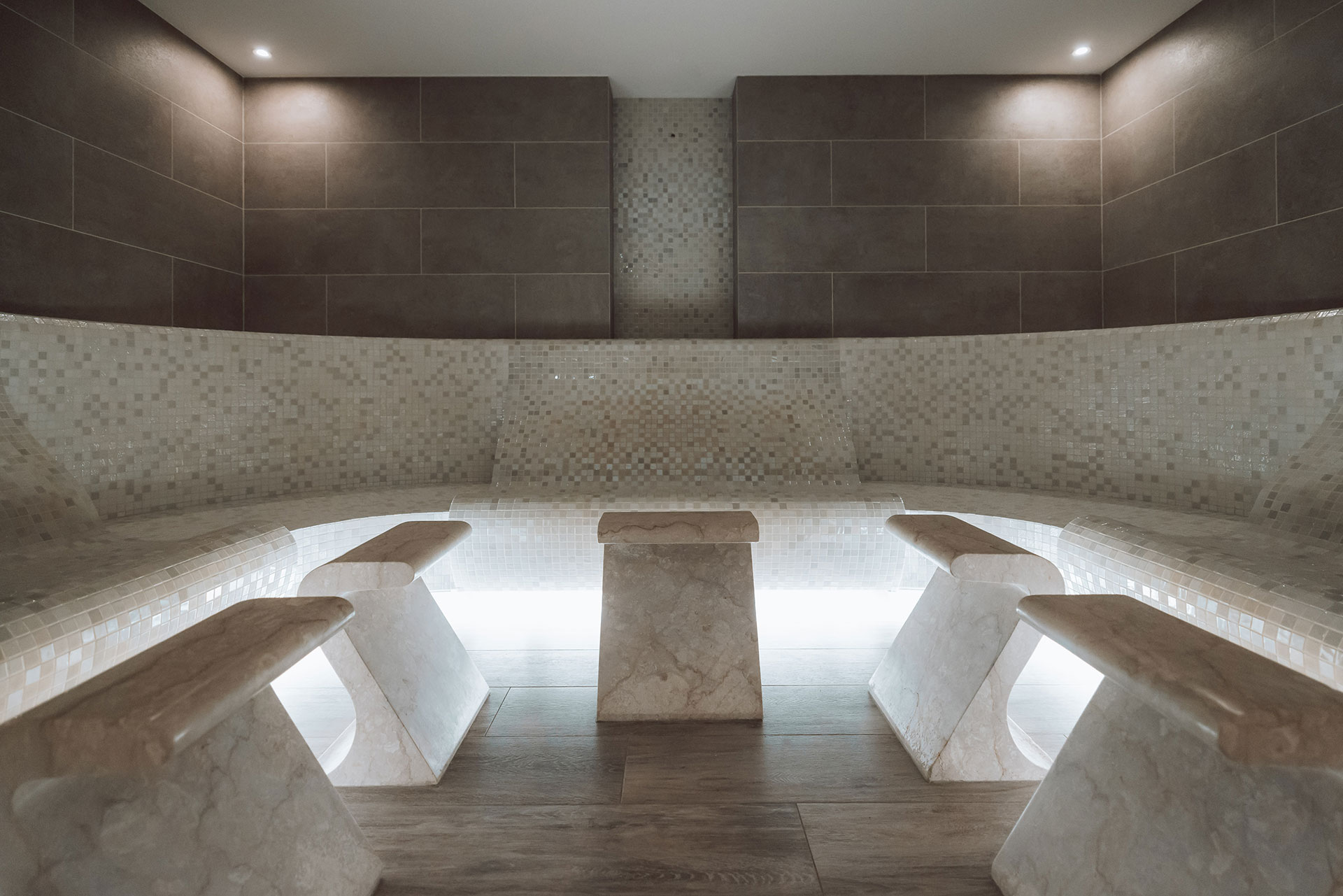 Elegant steam room with mosaic tiles and soft ambient lighting