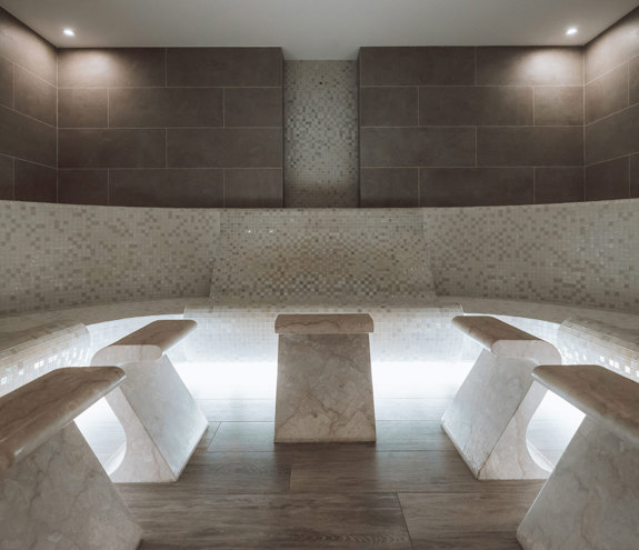 Elegant steam room with mosaic tiles and soft ambient lighting