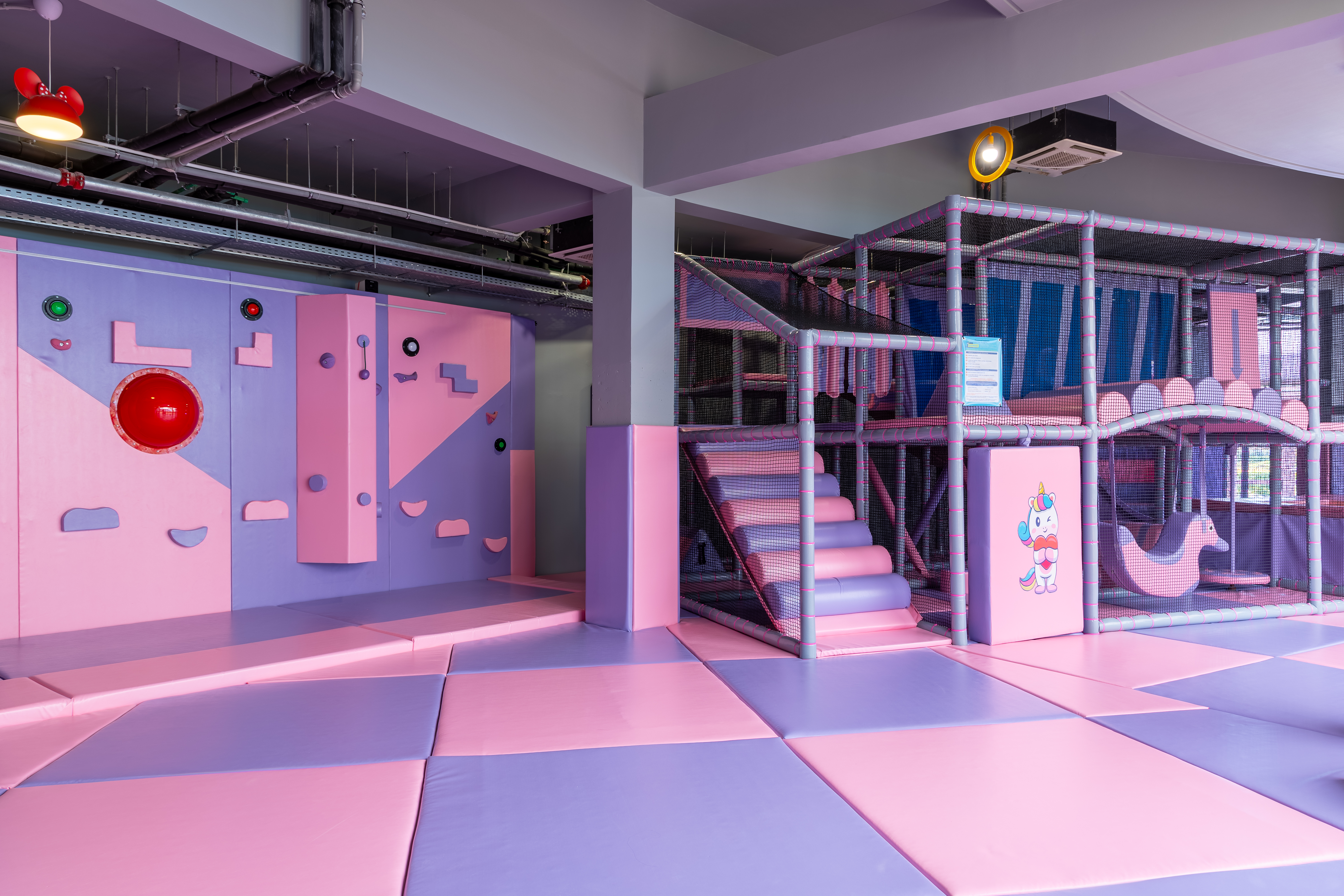 Playroom with climbing wall, padded floors, and soft play zone at Kids Planet