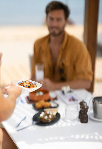 A dish being served by the waiter to the customer