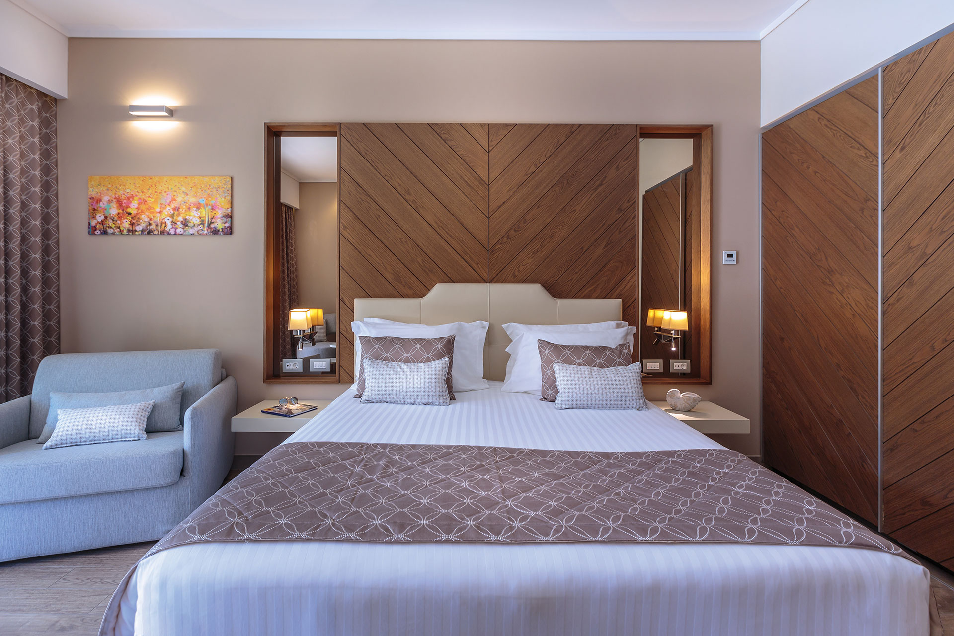 Superior room with king bed, elegant wooden wall panel and cozy seating area with artwork