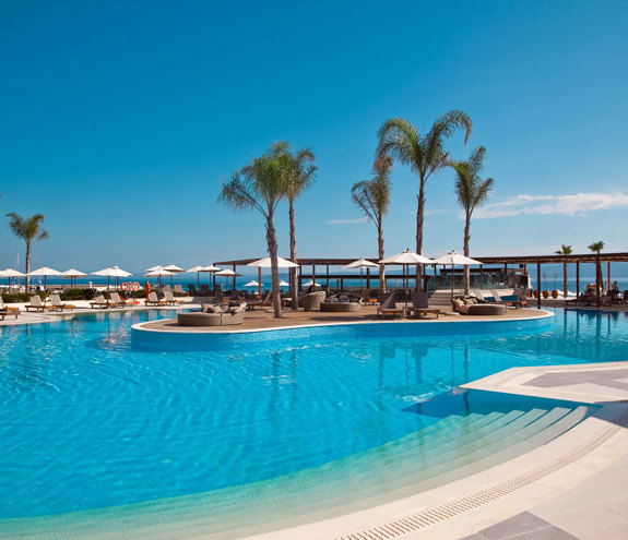The big pool, palm trees, sunbeds and umbrellas