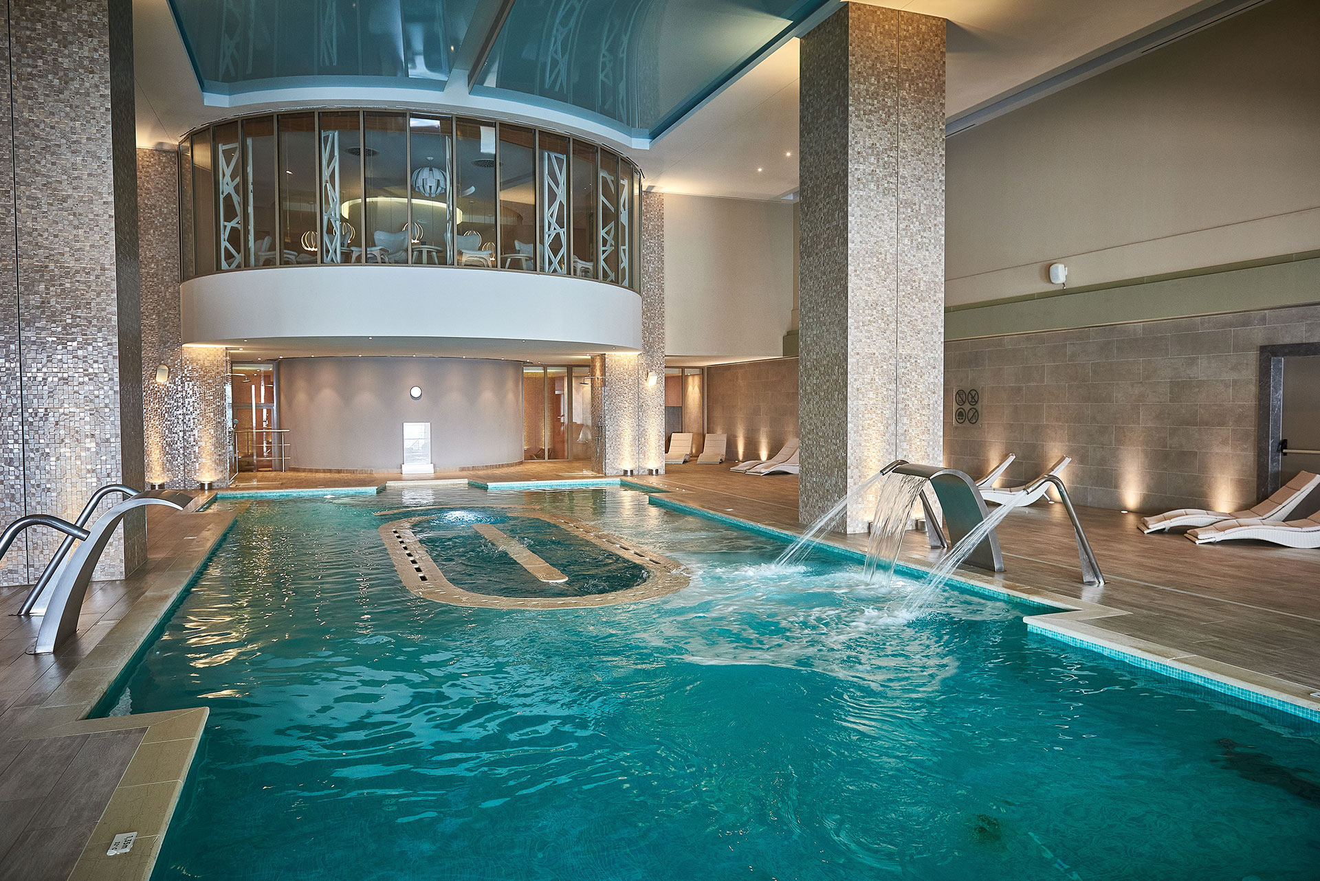 Luxurious indoor hydrotherapy pool with water jets and relaxation loungers