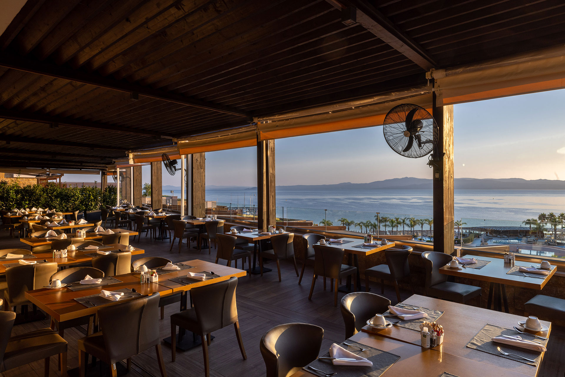 Elegant indoor-outdoor dining area with sunset sea view at Kritamo restaurant