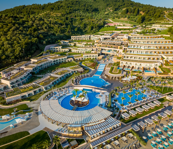 Aerial view of Miraggio Thermal Spa Resort showcasing terraced architecture, pools, cabanas, surrounded by lush hills