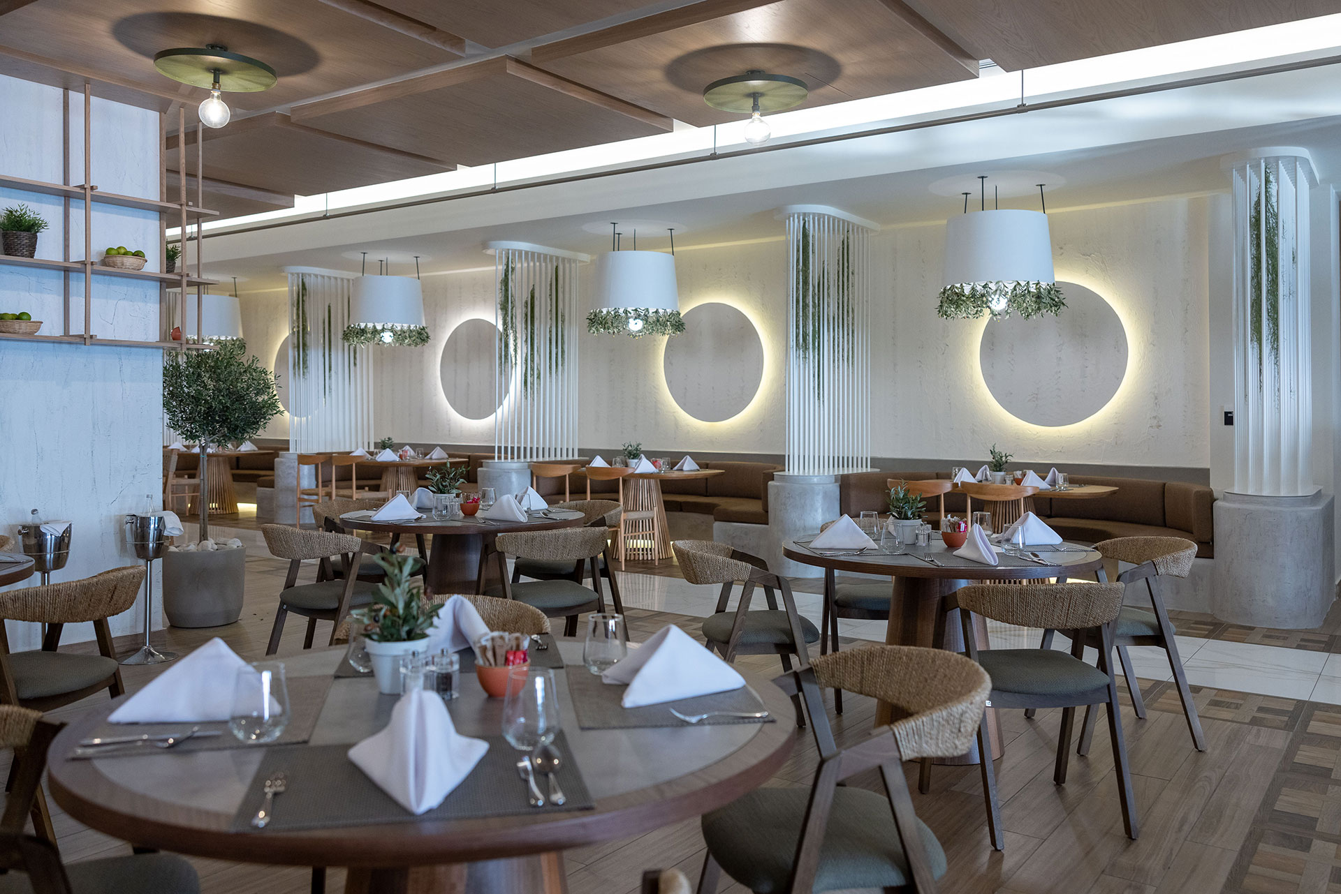 Elegant dining setup with wooden furniture, greenery accents, and warm ambient lighting at Elia restaurant