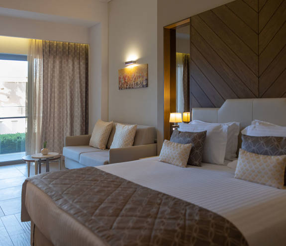 Deluxe Garden View Room side view of bed, sofa and balcony view