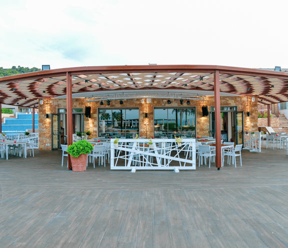 Front view of the circular oasis Pool Bar with shaded pergola and surrounding seating area