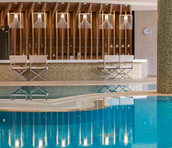 Elegant indoor spa bar with modern lighting and pool reflection