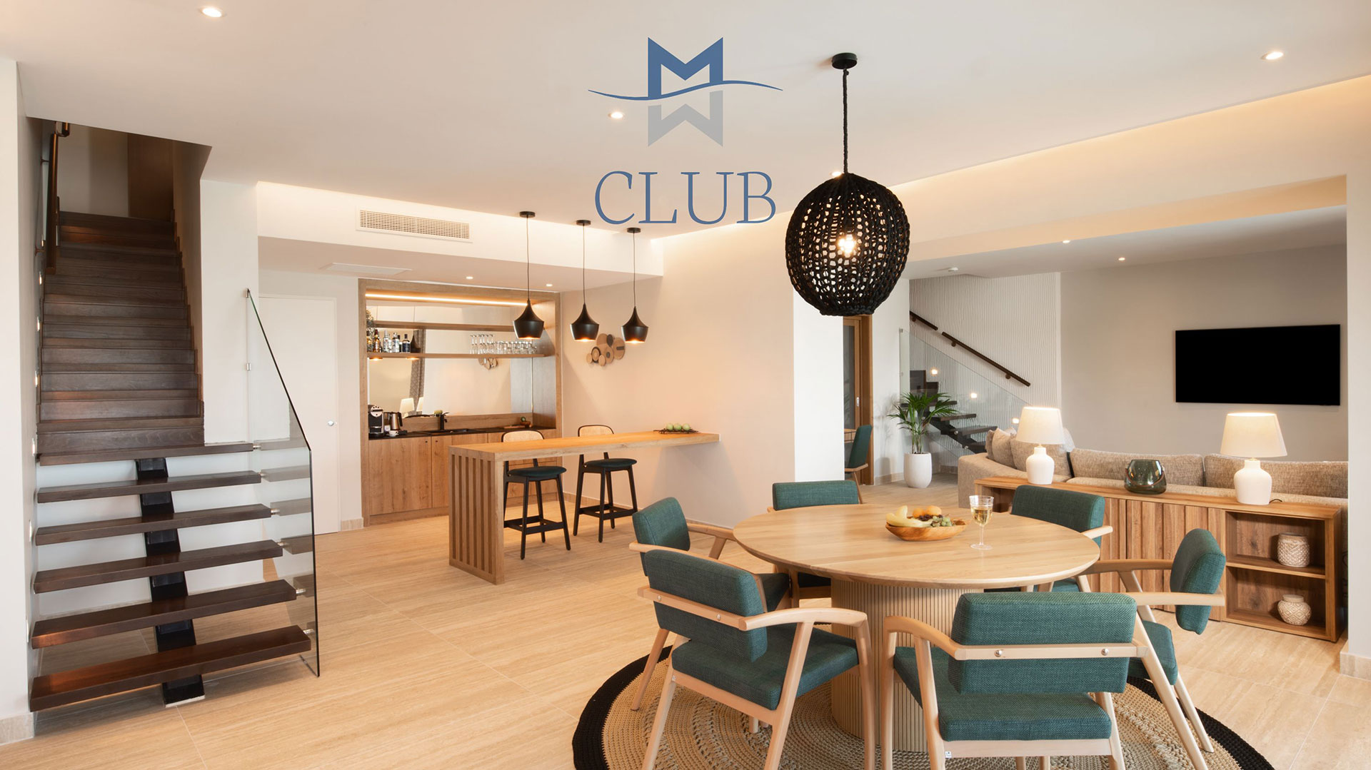 Elegant interior of duplex suite, with dining area, minibar, living area and floating staircase