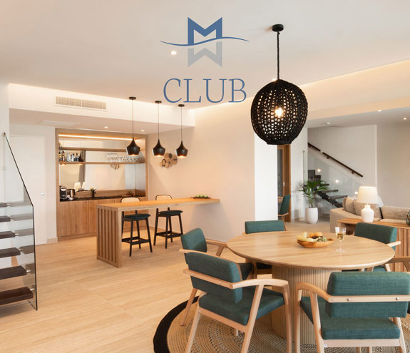 Elegant interior of duplex suite, with dining area, minibar, living area and floating staircase