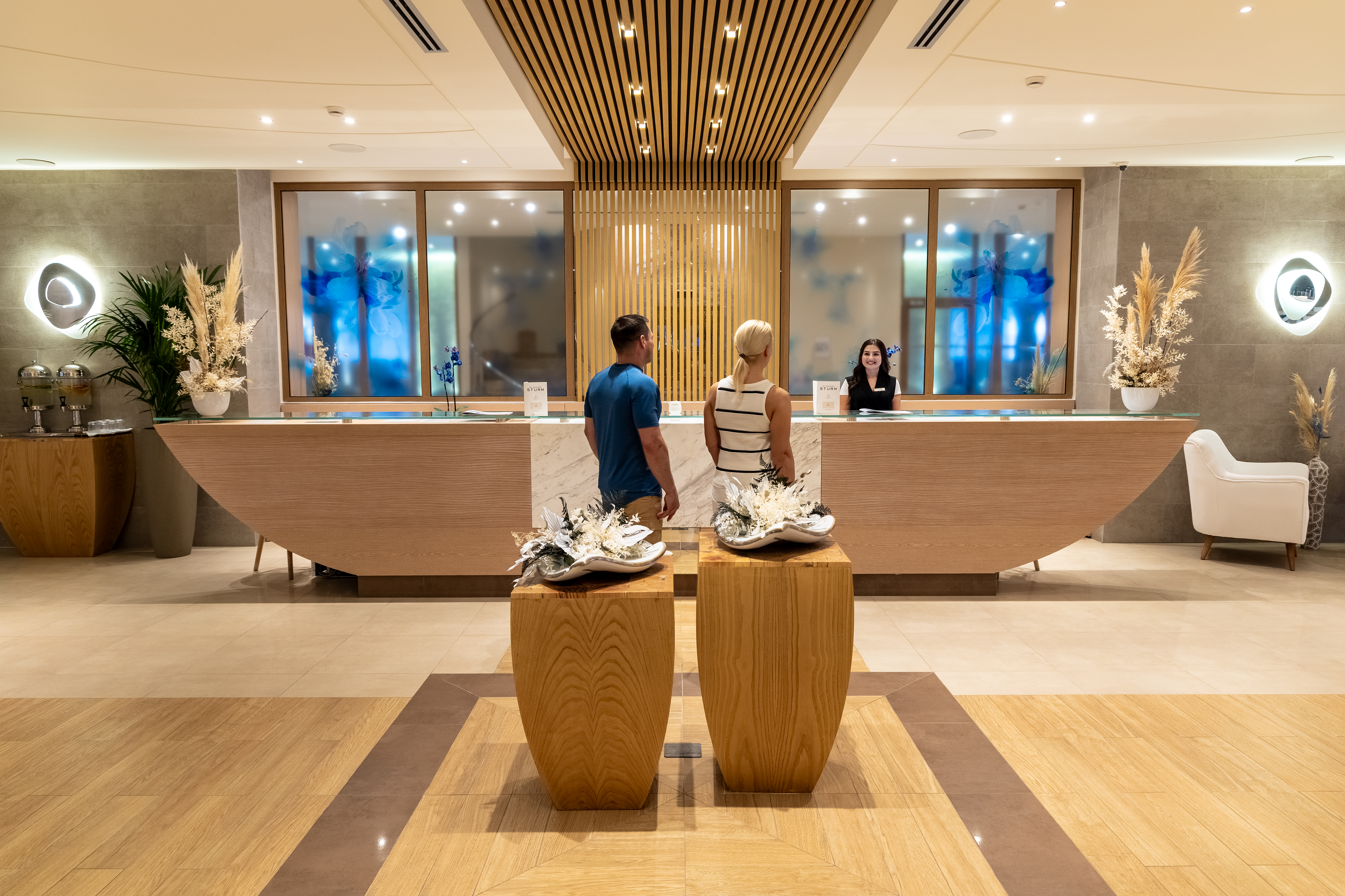 Guests at the luxurious Myrthia Thermal Spa reception with elegant wooden design