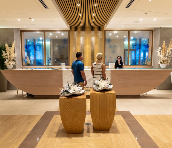 Guests at the luxurious Myrthia Thermal Spa reception with elegant wooden design