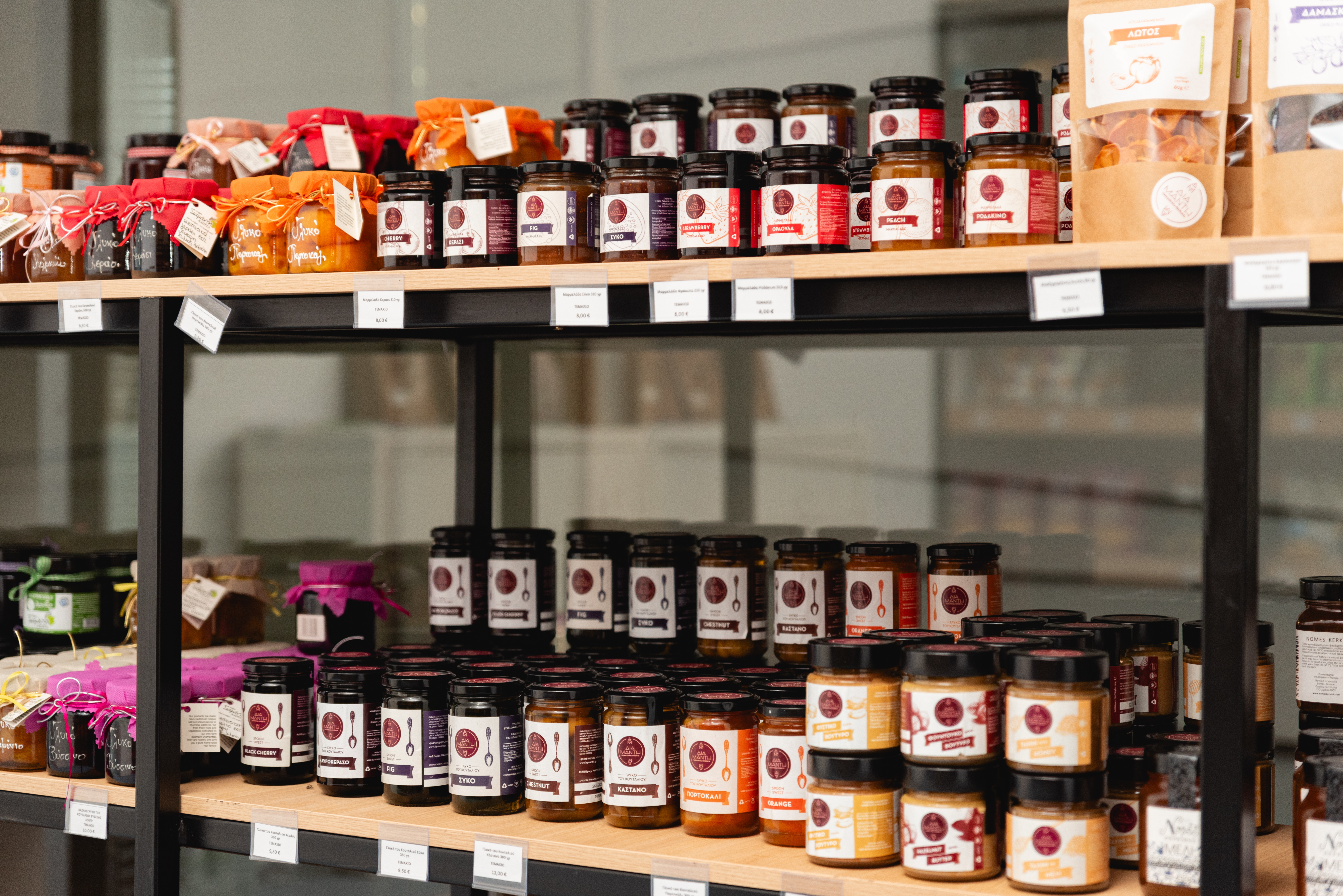Display of local Greek jams, spoon sweets, and preserves neatly arranged on wooden shelves
