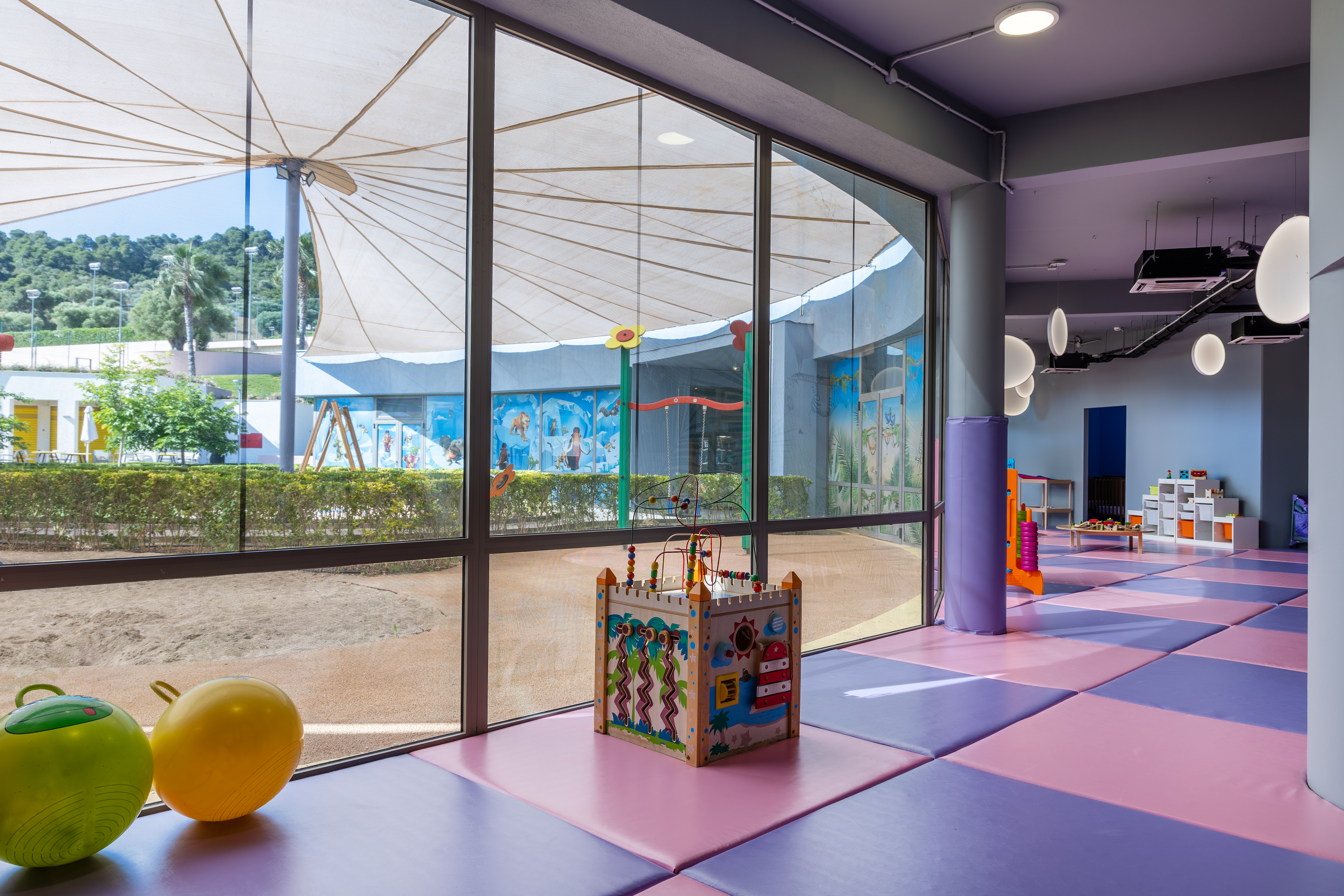 Bright indoor play area with large windows and colorful toys at Kids Planet