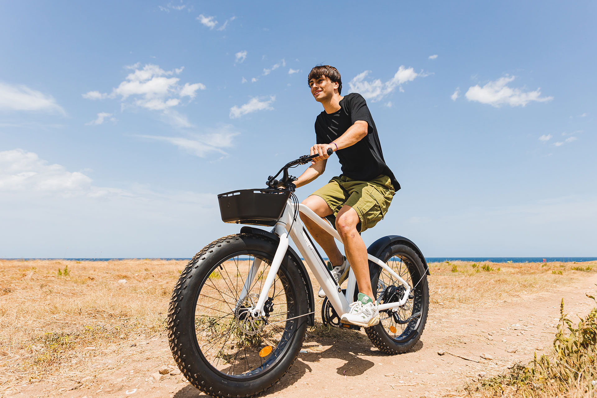 Guest enjoying an electric bike ride along the coastal trails under the blue sky