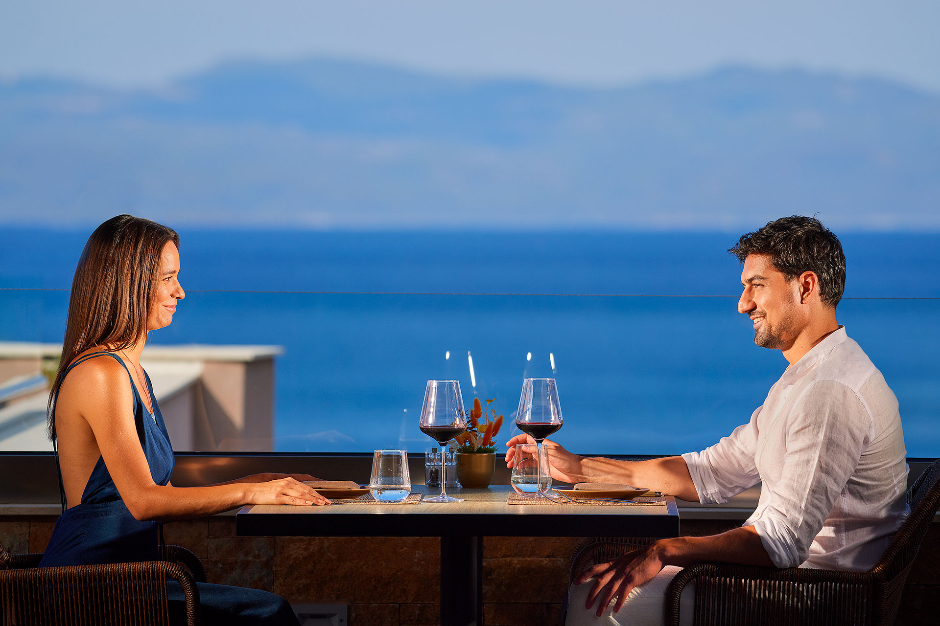 Couple enjoying a romantic dinner with sea view at Sommelier's 8 restaurant terrace