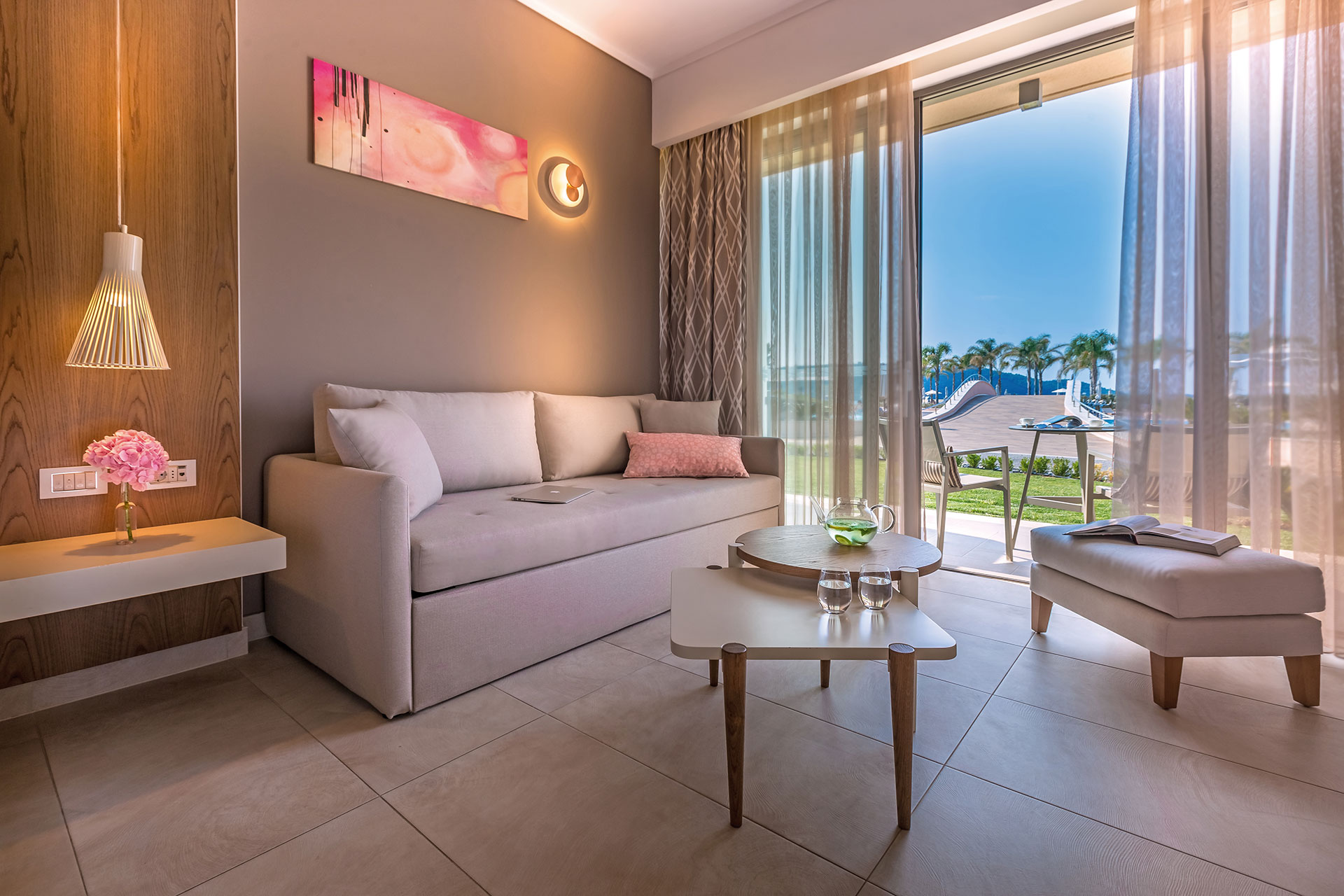 Deluxe room's seating area, with ambient lighting, wall artwork, wooden details and pool view