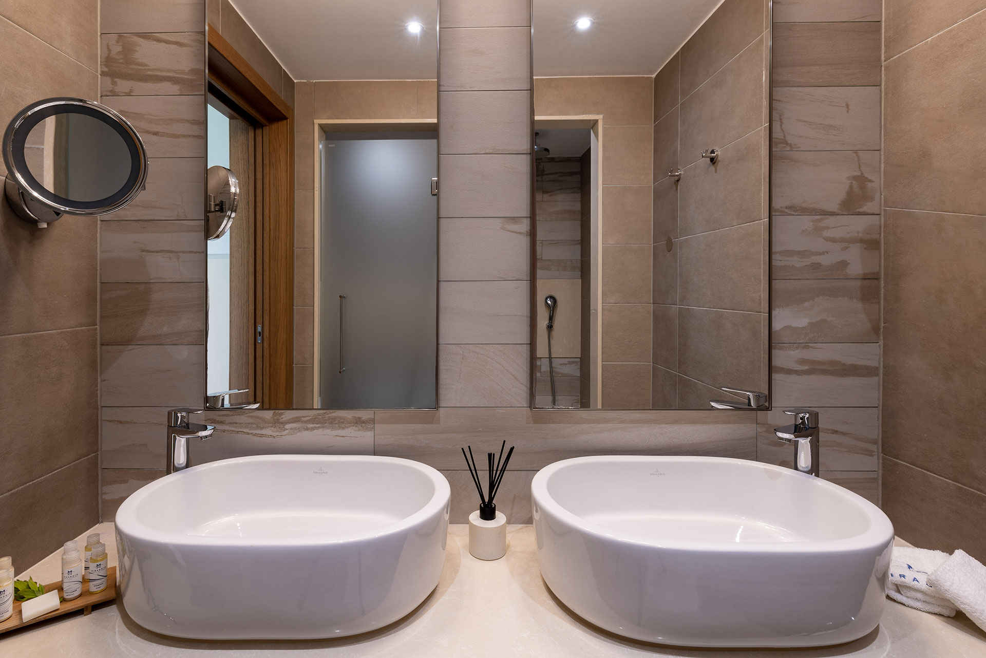 Elegant bathroom with twin basins, modern beige tiles and premium amenities