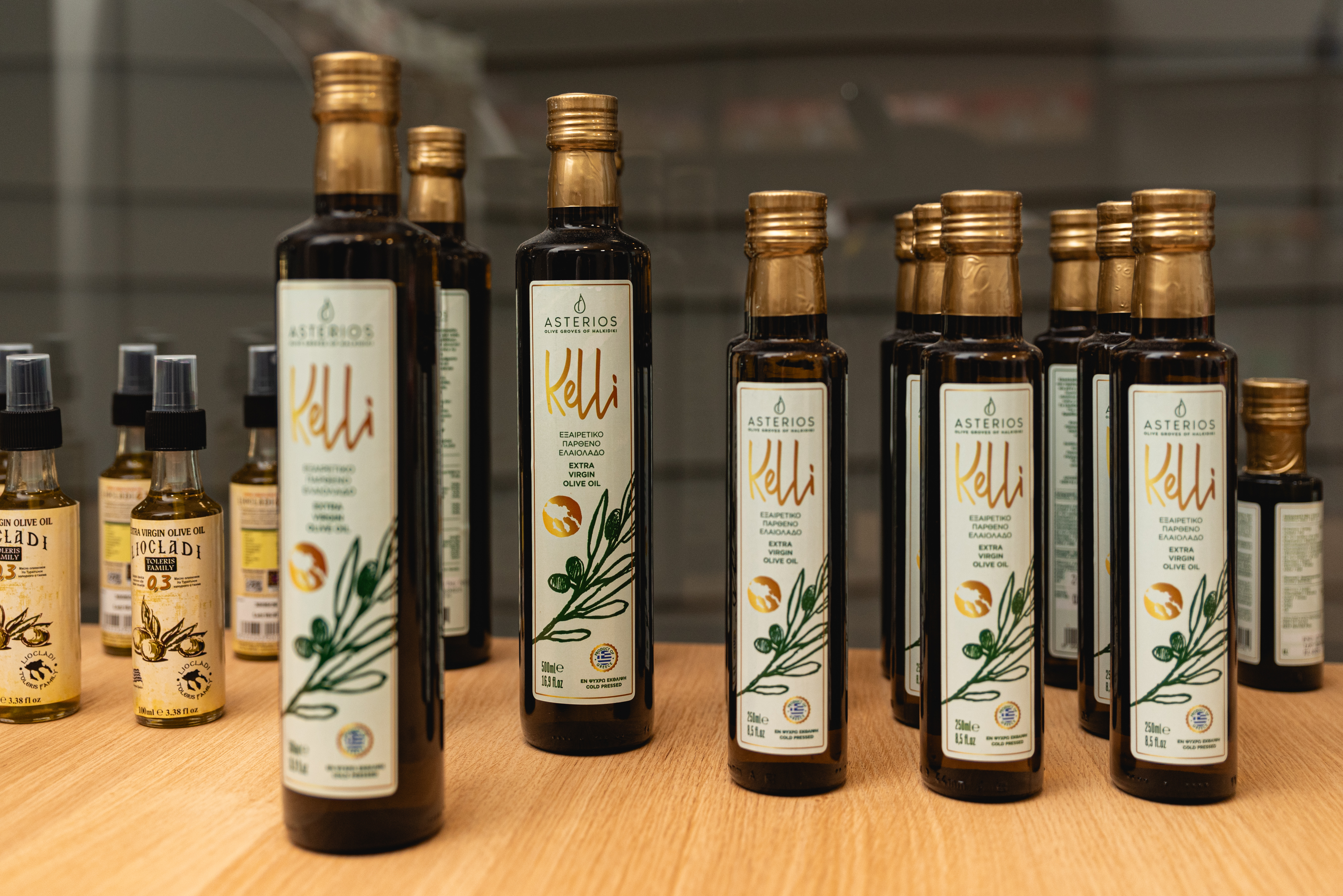 Bottles of premium Greek extra virgin olive oil "Kelli" neatly displayed on a wooden shelf