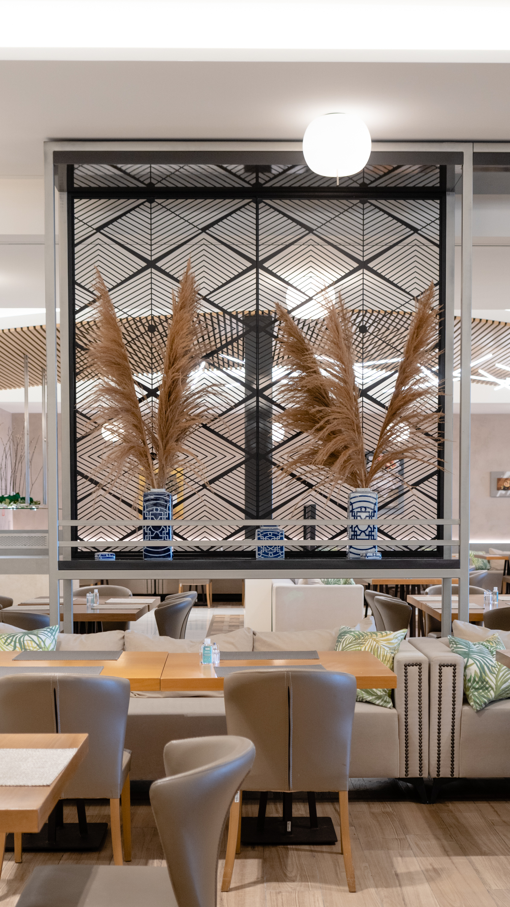 Modern restaurant interior decorated with stylish vases and green plants